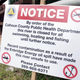 A sign is posted on a bridge to indicate water contamination after an oil spill of approximately 800,000 gallons of crude in the Kalamazoo River July 28, 2010 in Marshall, Michigan. A 30 inch-wide underground pipeline owned by Calgary, Alberta-based Enbridge Energy Partners LP, began leaking on June 26.